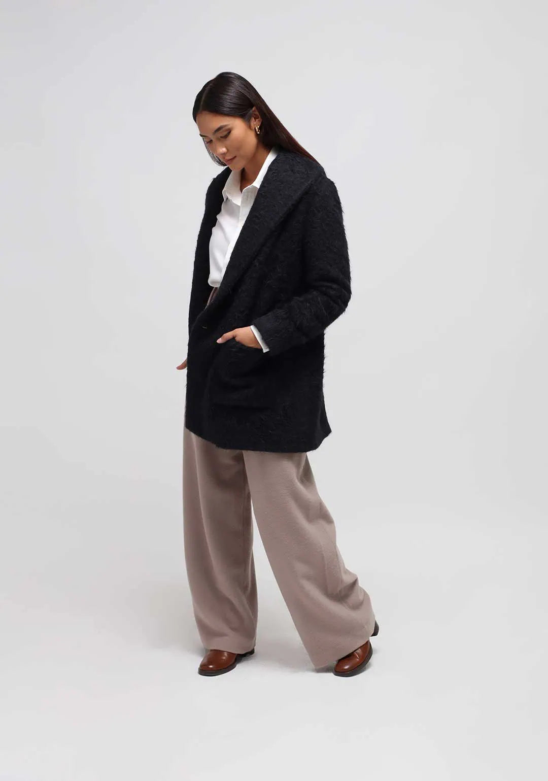 A woman wearing a winter short black coat in alpaca y Humans & Land