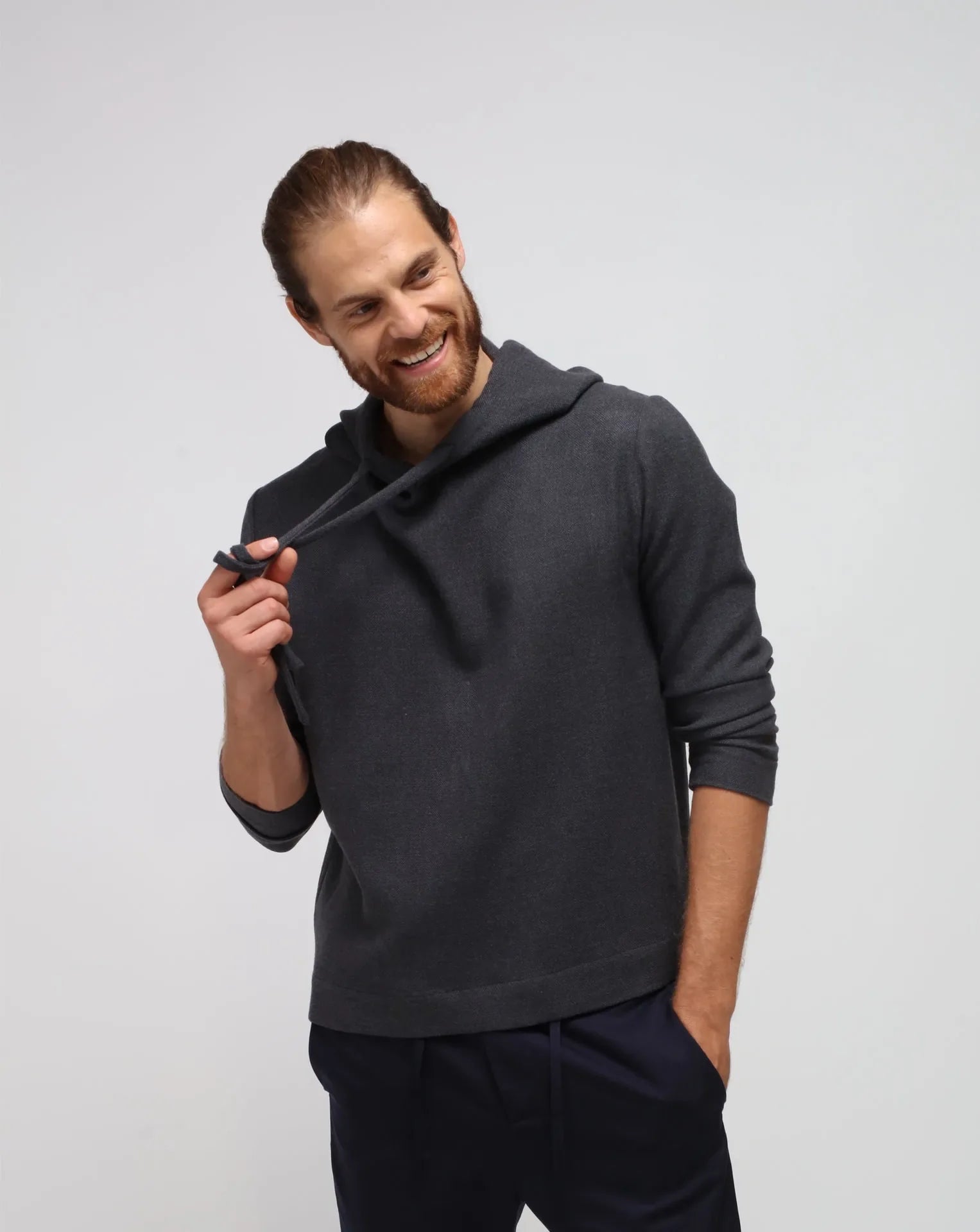 A man wearing a cashmere hoodie and blue cupro traveler pants.