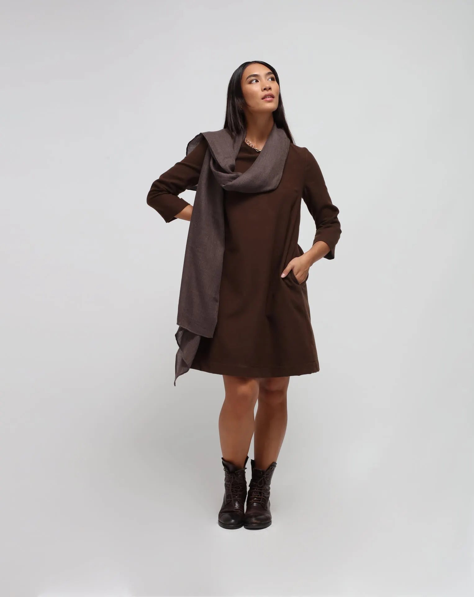 A woman wearing an oversized brown cashmere scarf draped over her shoulders.