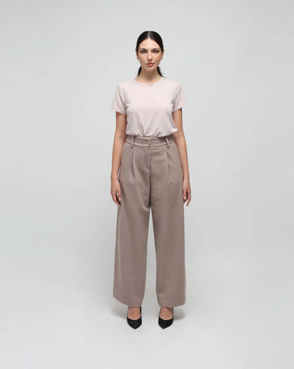 Woman wearing grey wool palazzo pants pleated.