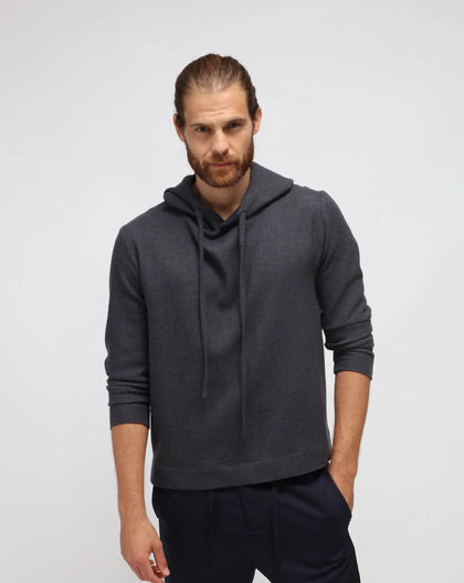 A male model wearing a gray hoodie with the hood up, showcasing the mixed cashmere fabric.