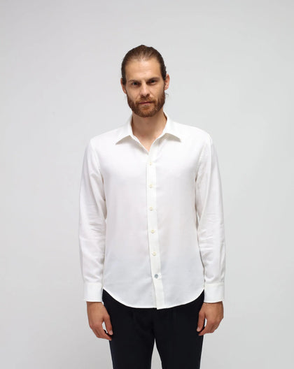 A man wearing a classic white long-sleeved shirt.