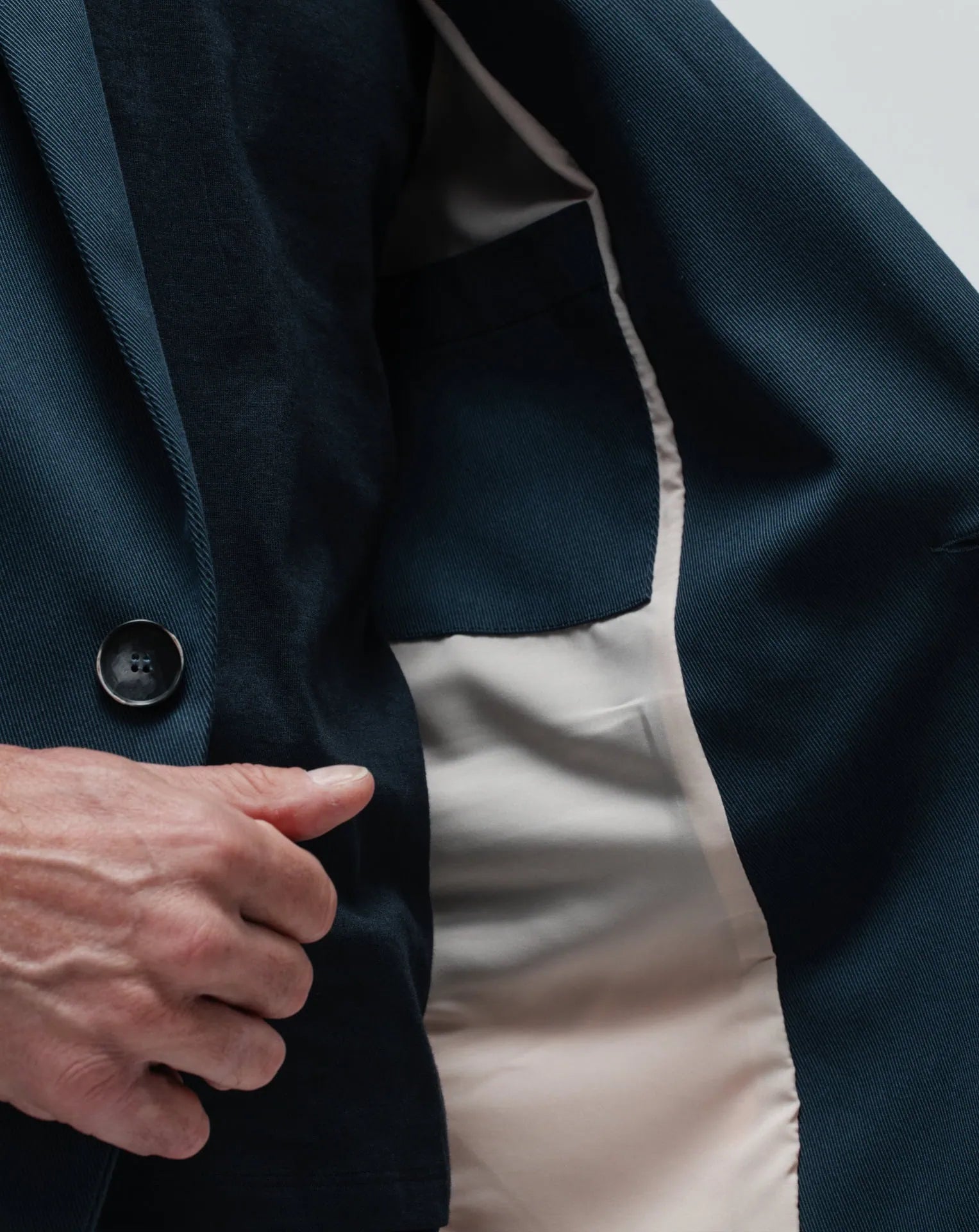 A detail of the inside pocket of a gabardine blue one-button jacket.