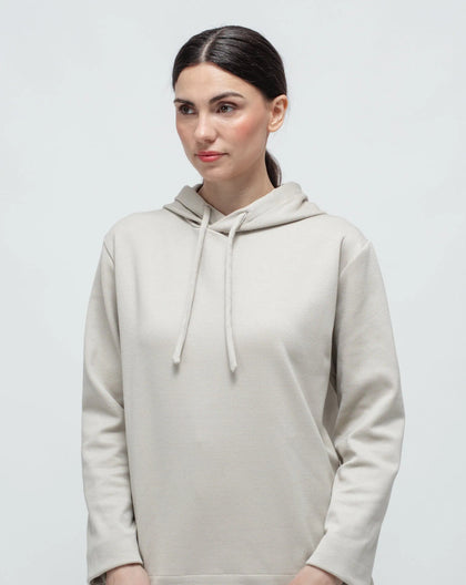 A woman on white background wearing a beige punto Milano hoodie.