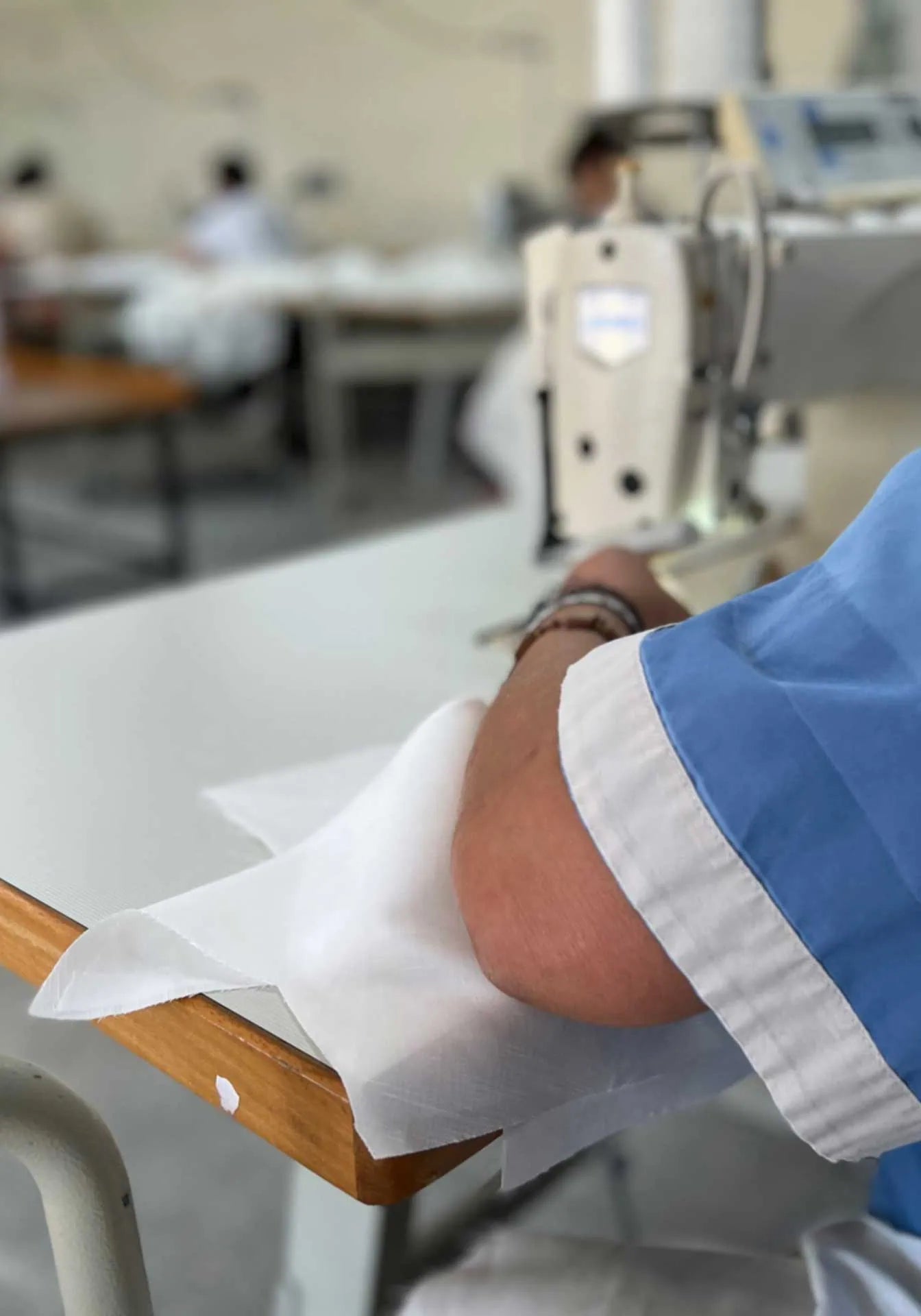 Hand of a seamstress sewing a fashion item in Italy