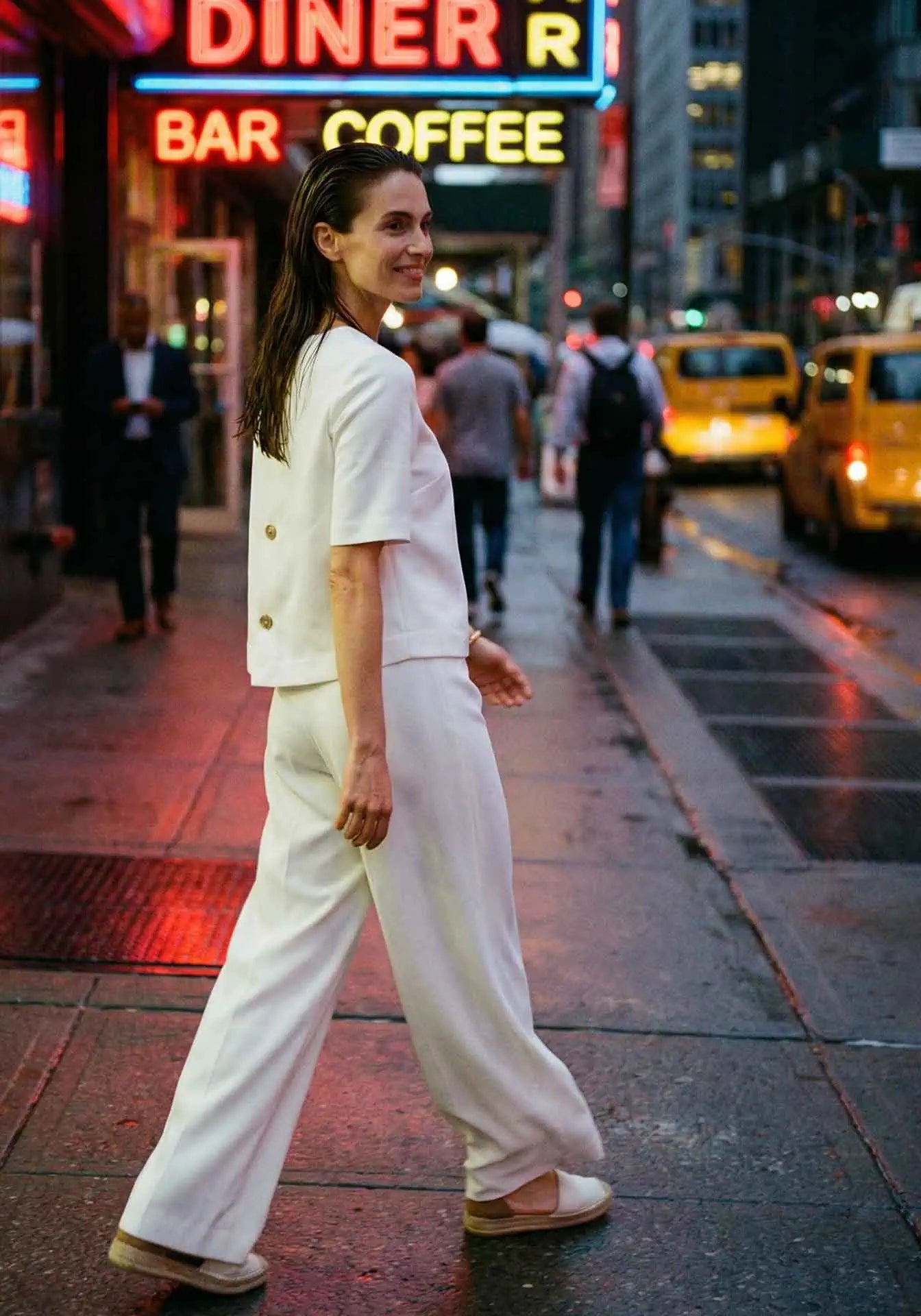 Woman wearing a white top and palazzo pants walking in Midtown Manhattan