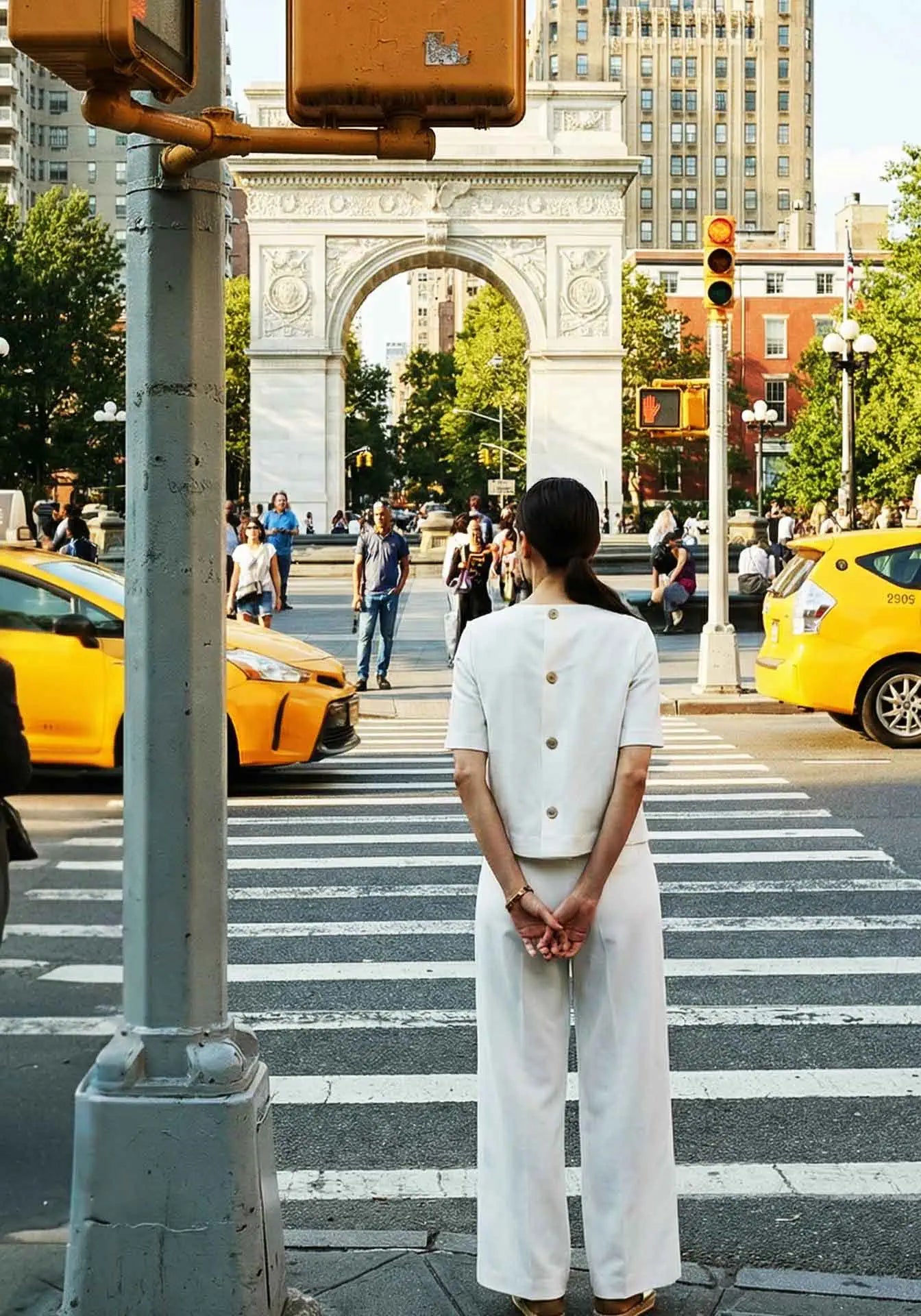 A woman wearing a Milano Stitch white top and pants at Washington Square Park in NYC.