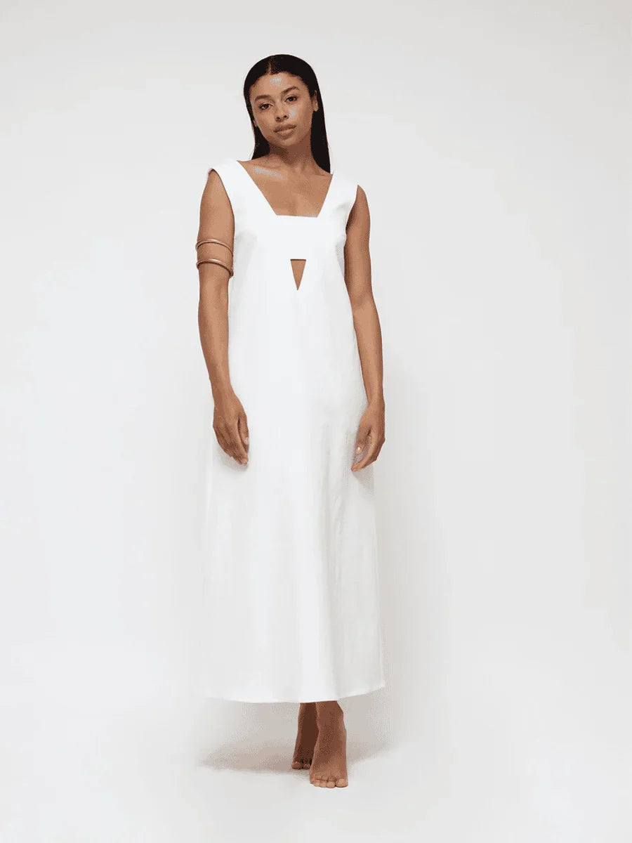 A woman wearing a white dress on a seamless white background.