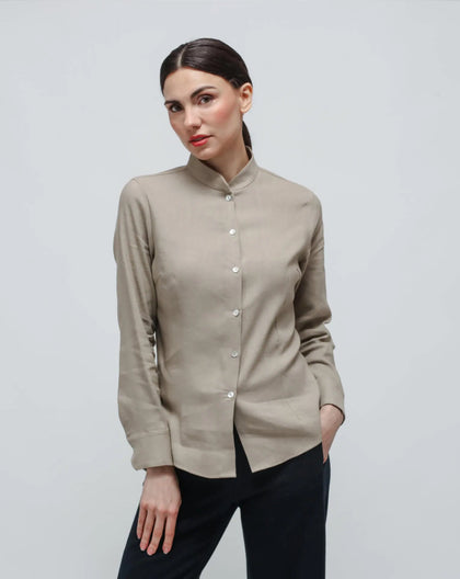 A woman wearing a beige, slim-fit Korean shirt with a pointelle texture, featuring a round neckline and long sleeves.