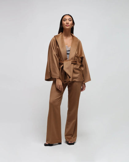 A woman wearing a camel kimono jacket in zibeline wool.