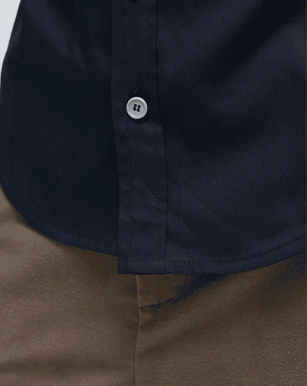 Close-up of button on a navy Korean shirt- worn over a brown pants.